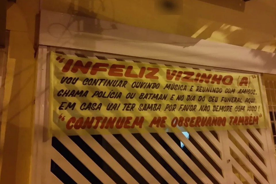 Mulher coloca placa em frente de casa, após denúncia de vizinhos: “Vou continuar fazendo festa”